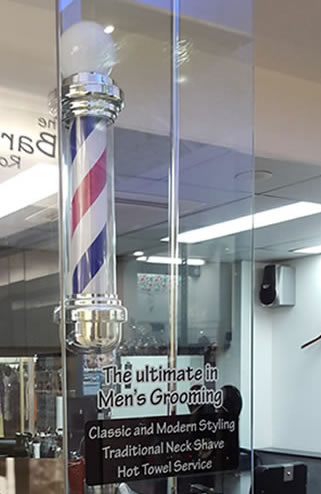 Bright barber pole lighting up main glass shop window of 'The Barber Room' traditional barber shop in Blocksidge Arcade, 144 Adelaide Street Brisbane City